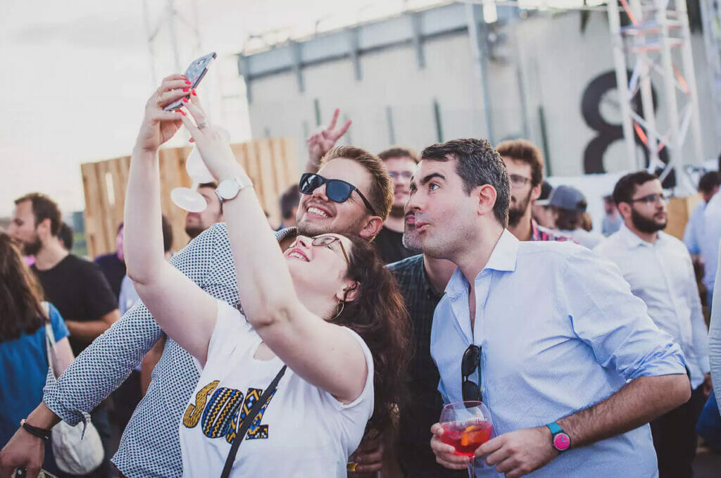 Un groupe de personne à une fête se prend en selfie.