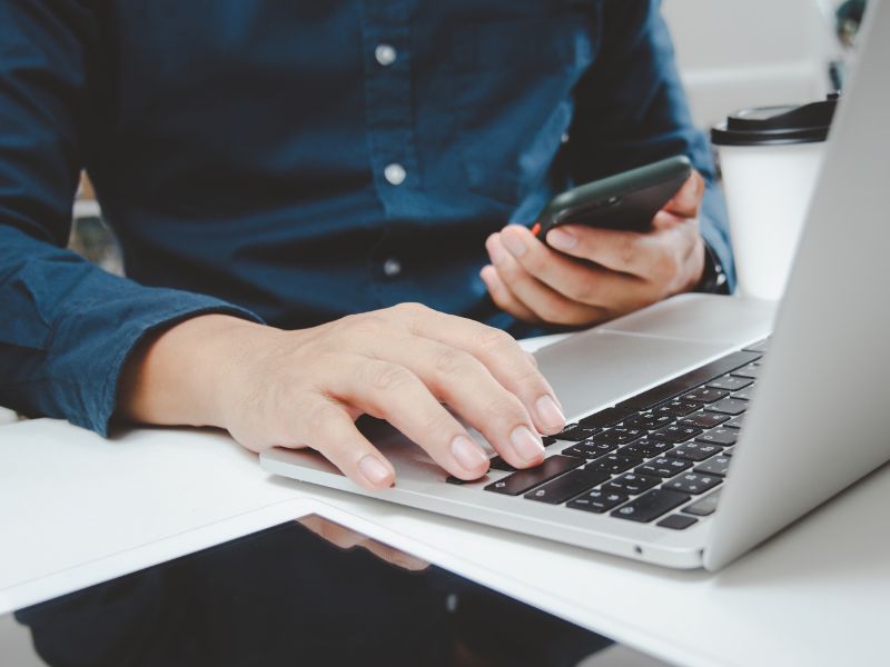 Homme sur un smartphone et un ordinateur