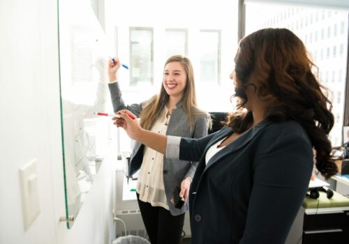 Deux employés écrivent sur un tableau