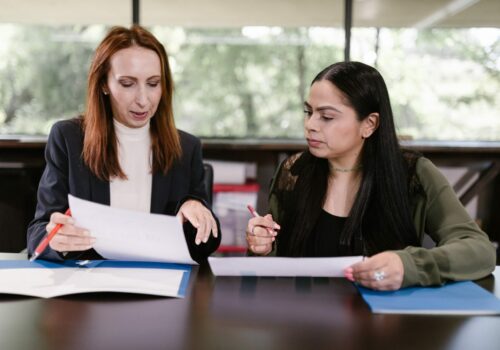 Deux femmes au travail échangent sur des documents